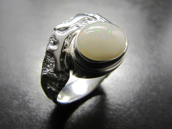 Atelier Solstice – Bague en argent avec motifs et Opale blanche.