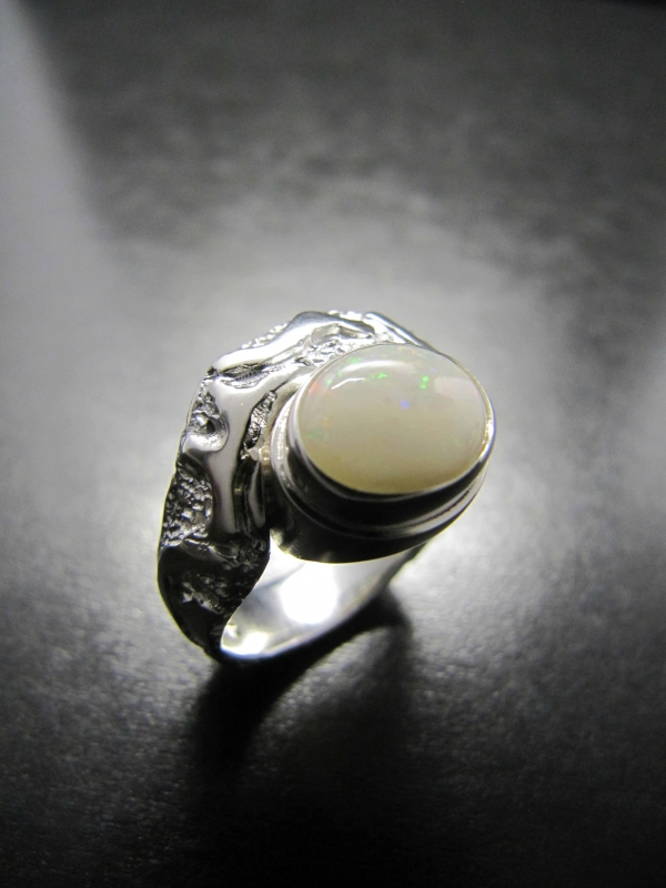 Atelier Solstice – Bague en argent avec motifs et Opale blanche.